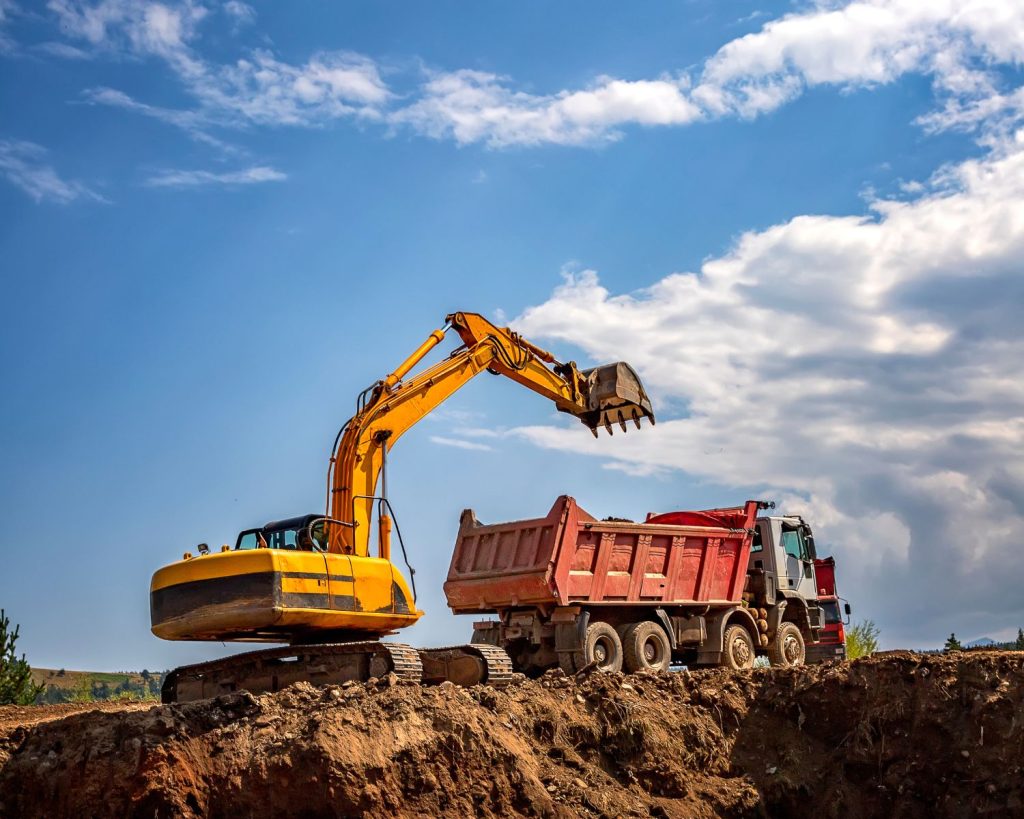 Tractopelle et camion benne sur un chantier de construction de maison