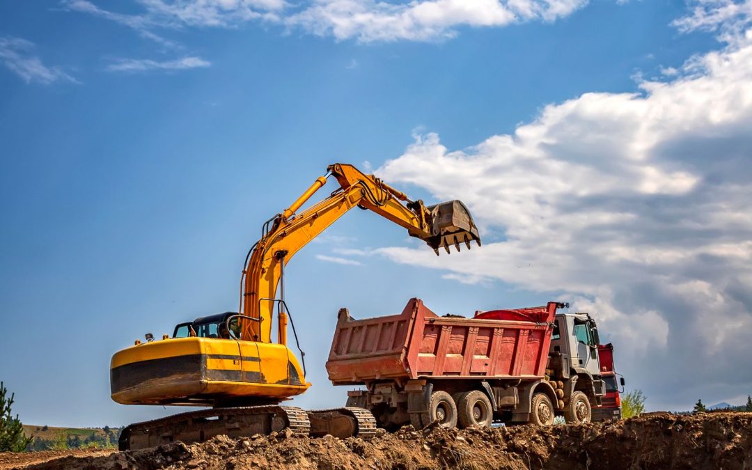 Tractopelle et camion benne sur un chantier de construction de maison