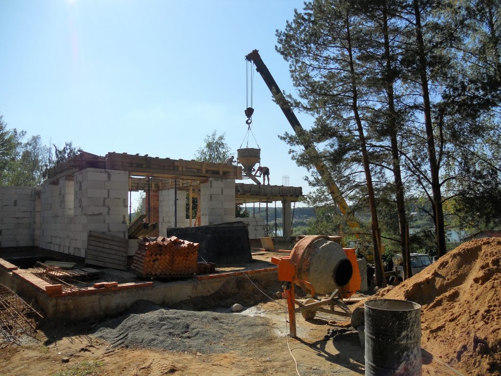 Maison en construction avec une bétonnière et une grue