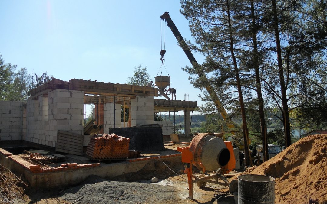 Maison en construction avec une bétonnière et une grue